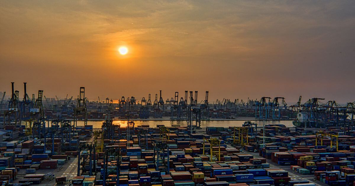 Containers in a sea port, under the sunset